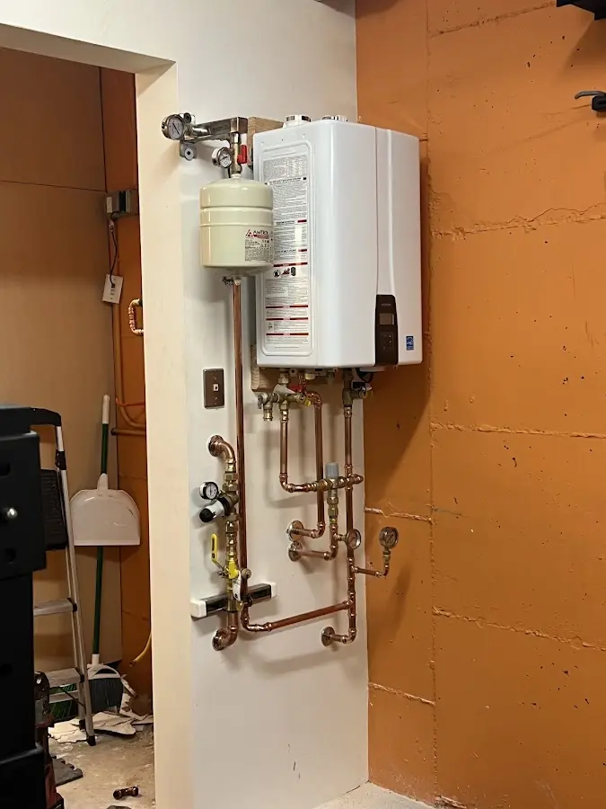 Plumbing technician inspecting water heater connections in Highlands Ranch
